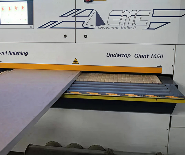 Vista ravvicinata di una macchina industriale EMC, con apertura e barra di sicurezza del modello “Undertop Giant 1650”